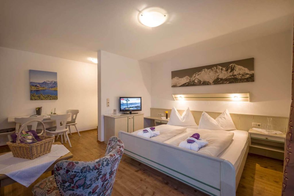 Stilvolles Hotelzimmer im Penzinghof mit Bergblick, gemütlicher Einrichtung und TV.