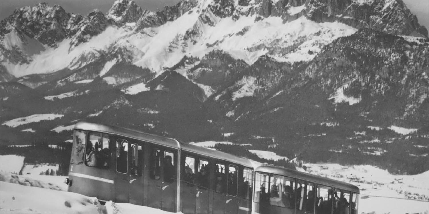 Téléphérique historique en hiver avec les Alpes tyroliennes enneigées en arrière-plan.