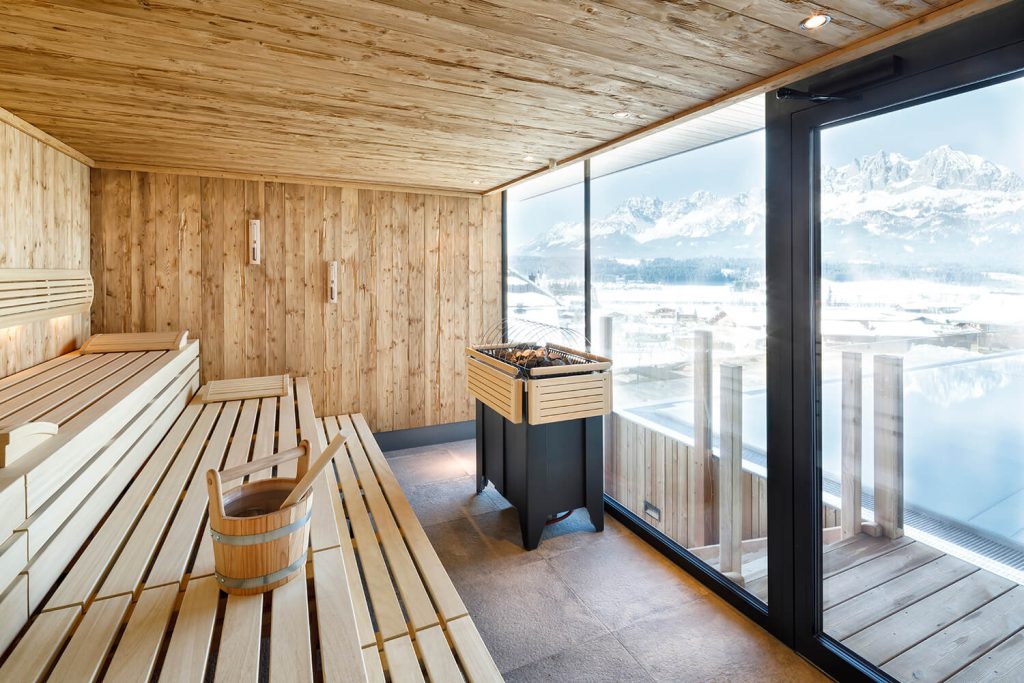 Sauna moderna con vista panoramica sulle Alpi tirolesi innevate nell'Hotel Penzinghof.