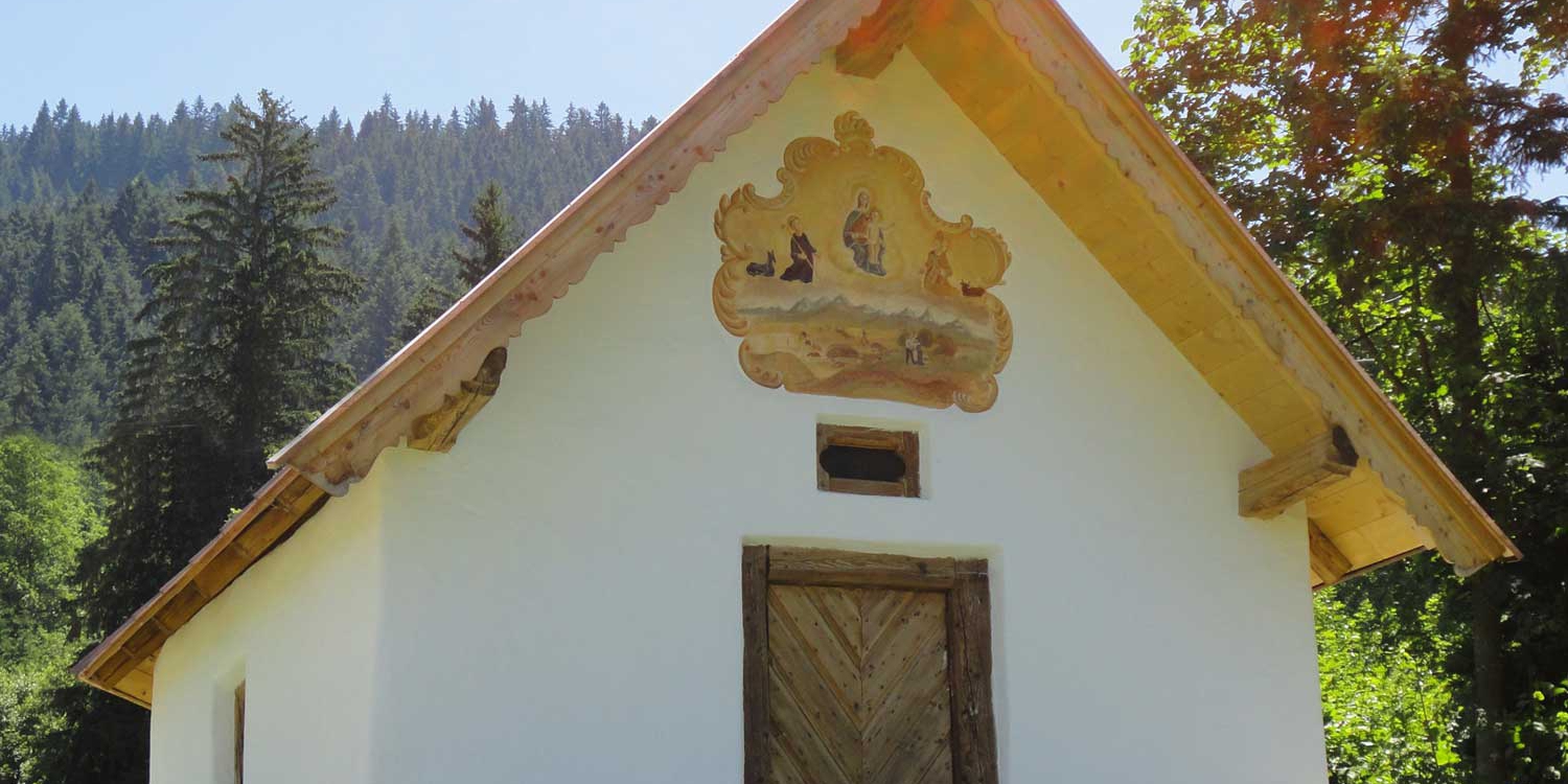 Dickat Chapel on a Hill, with Wooden Decor and Surrounding Forest Landscape.