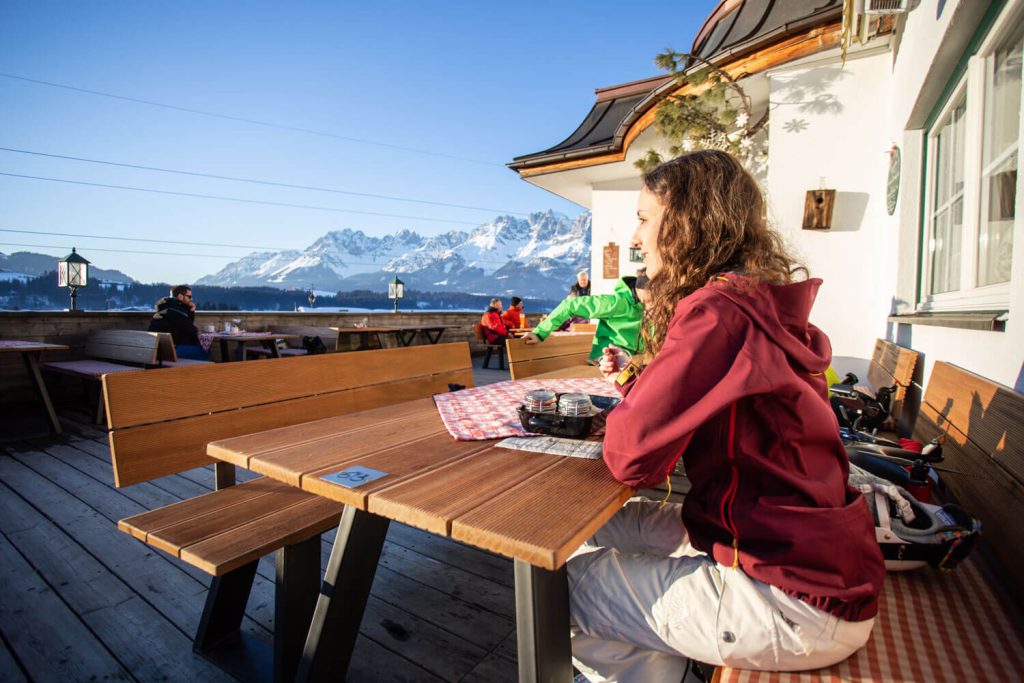 Frau im Außencafé des Hotel Penzinghof mit Blick auf die Tiroler Alpen.