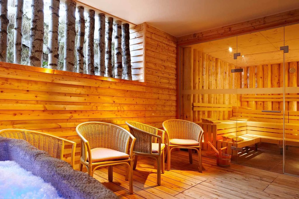 Espace spa confortable avec sauna en bois et chaises en rotin accueillantes à l'Hotel Penzinghof.