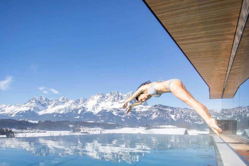 Un tuffo nell'acqua con vista sulle montagne sullo sfondo, lusso rilassante all'Hotel Penzinghof.