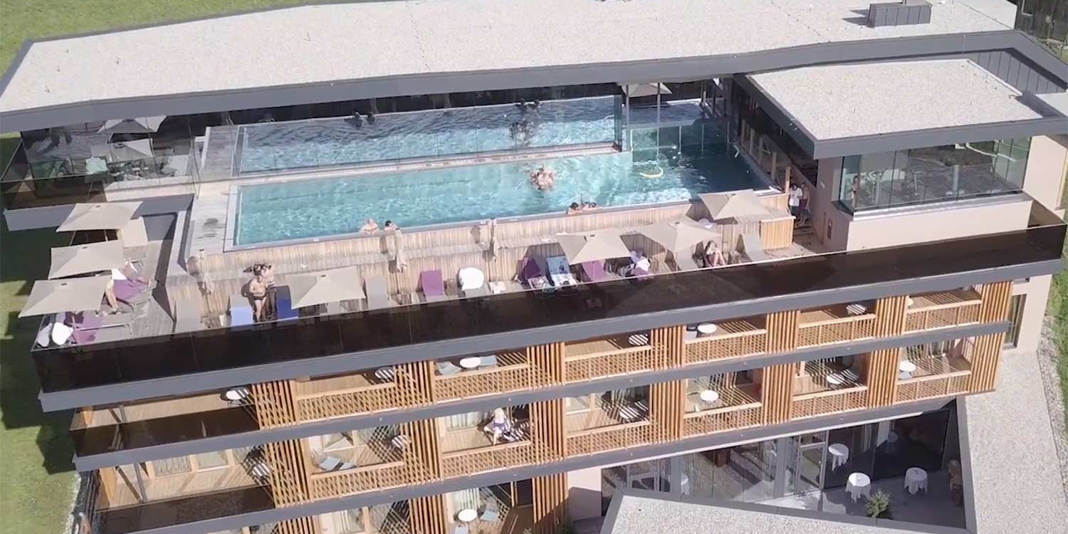 Complexe hôtelier moderne avec piscine et terrasses dans les Alpes tyroliennes. Idéal pour des journées de vacances reposantes.