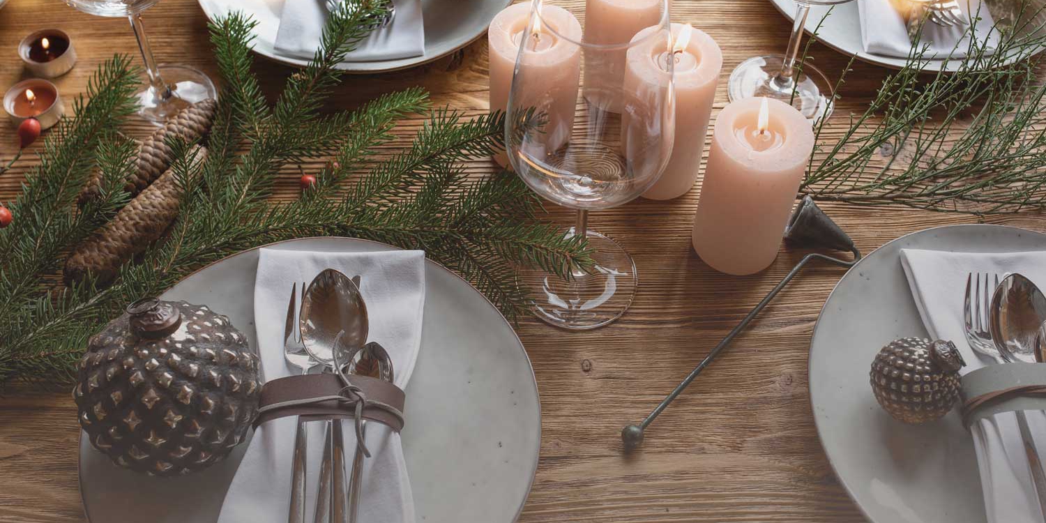 Festively set table with candles, decorated plates and natural decorations in Advent.
