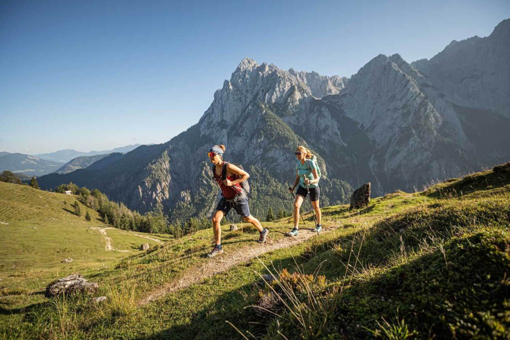 Active hikers explore the picturesque Tyrolean landscape with the Alps in the background.