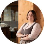 Herzliche Gastgeberin im Hotel Penzinghof, umgeben von traditionellem Charme und alpiner Atmosphäre.