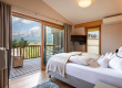 Bright bedroom with double bed, balcony, and views of the Tyrolean mountains