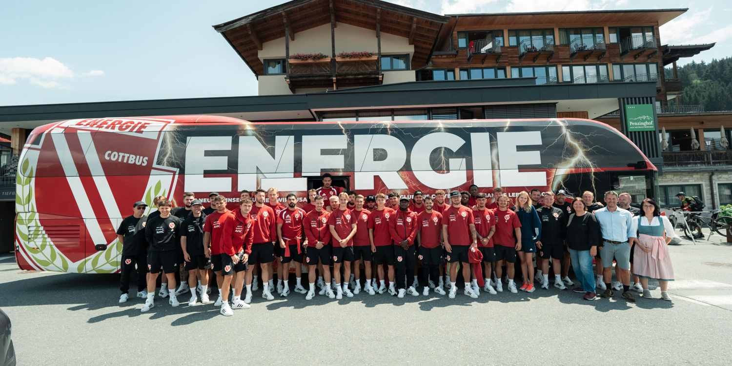 Energie Cottbus team poses in front of the team bus and Hotel Penzinghof