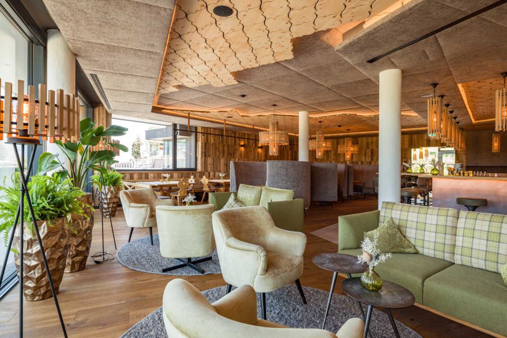 Elegante Lounge im Hotel Penzinghof mit stilvollen Möbeln und Pflanzen, einladende Atmosphäre.