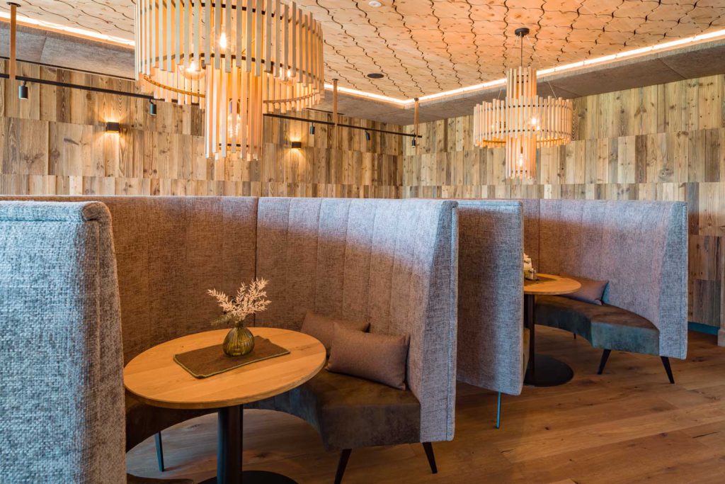 Gemütliche Sitzecken mit stilvollen Holztischen im Hotel Penzinghof.