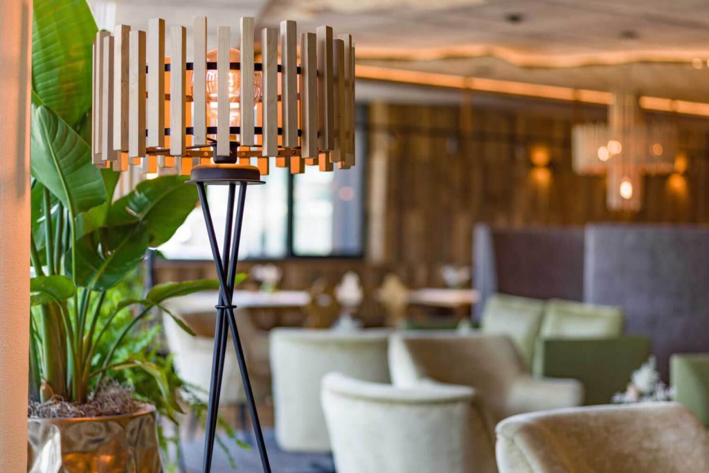 Moderne Stehlampe und Pflanzen im stilvollen Innenbereich des Hotels Penzinghof in Tirol.