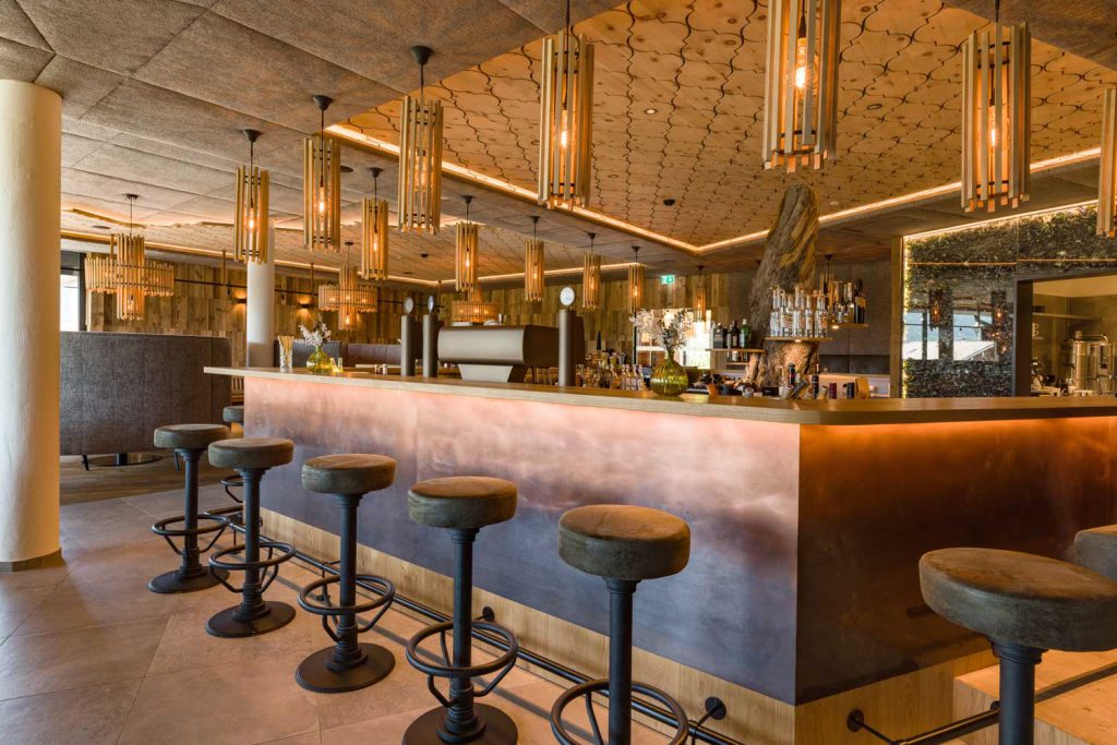 Moderne Hotelbar im Penzinghof mit stilvollen Hockern und gemütlicher Atmosphäre.
