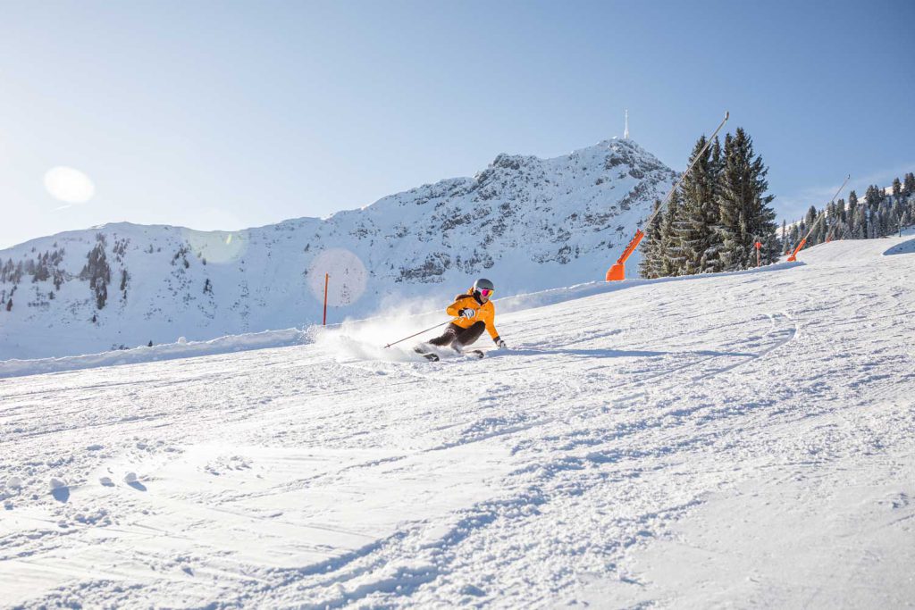 Skier in Bright Outfit, on a Snowy Slope in the Tyrolean Alps.