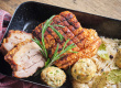 Crispy pork roast with sauerkraut and dumplings on a black plate