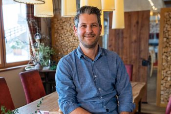 I padroni di casa dell'Hotel Penzinghof con un'atmosfera accogliente e decorazioni in legno. Vivi l'ospitalità tirolese.