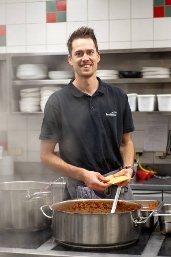 Chef dell'Hotel Penzinghof prepara piatti in una cucina moderna con ingredienti di alta qualità.