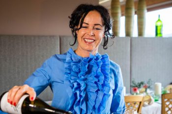 Padrona di casa serve vino nell'elegante ristorante dell'Hotel Penzinghof in Tirolo.